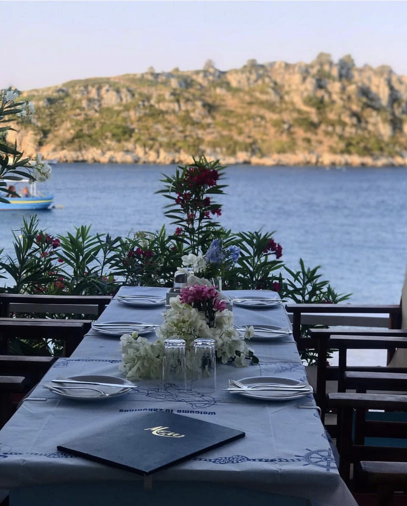 Seaside taverna table set for dinner overlooking Agios Nikolaos bay